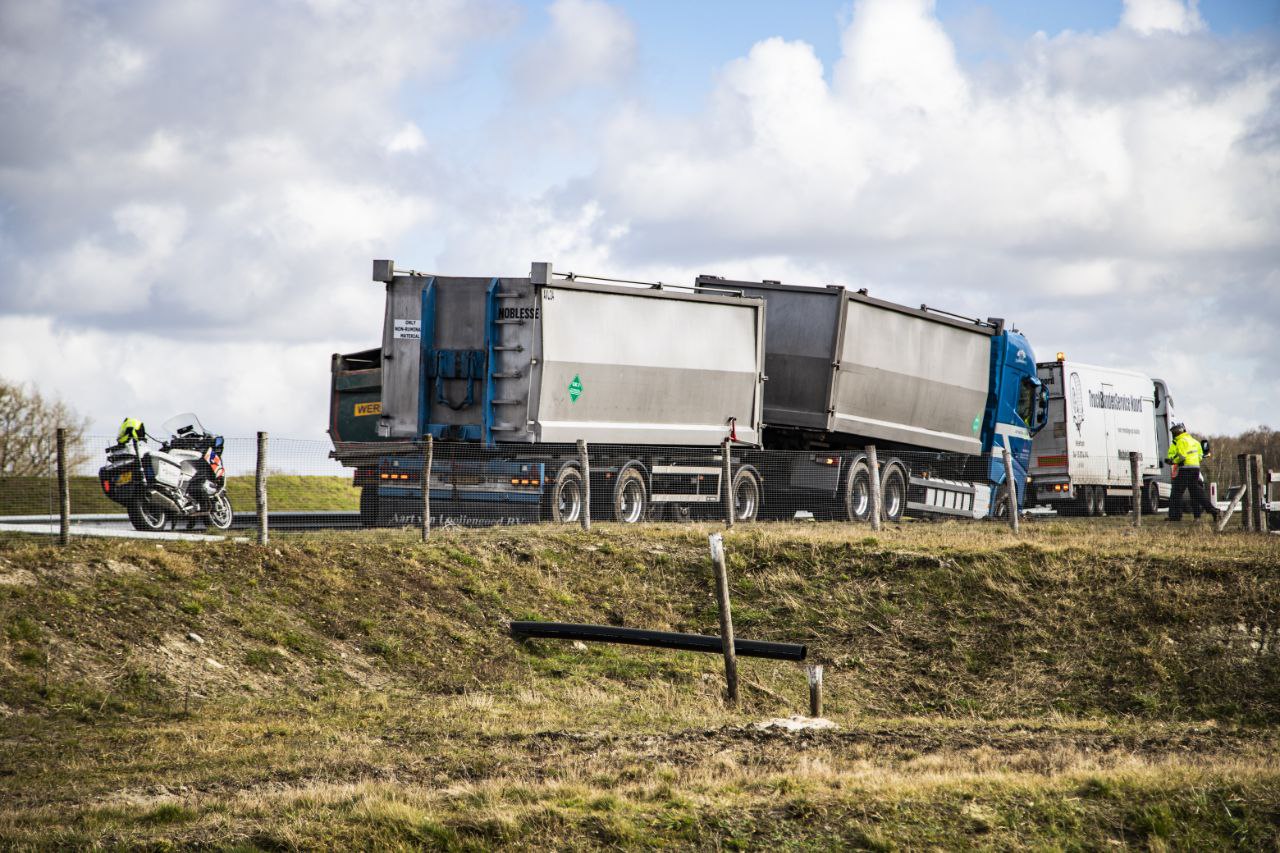 Vrachtwagen rijdt zich vast in berm bij Donkerbroek; auto botst op berger