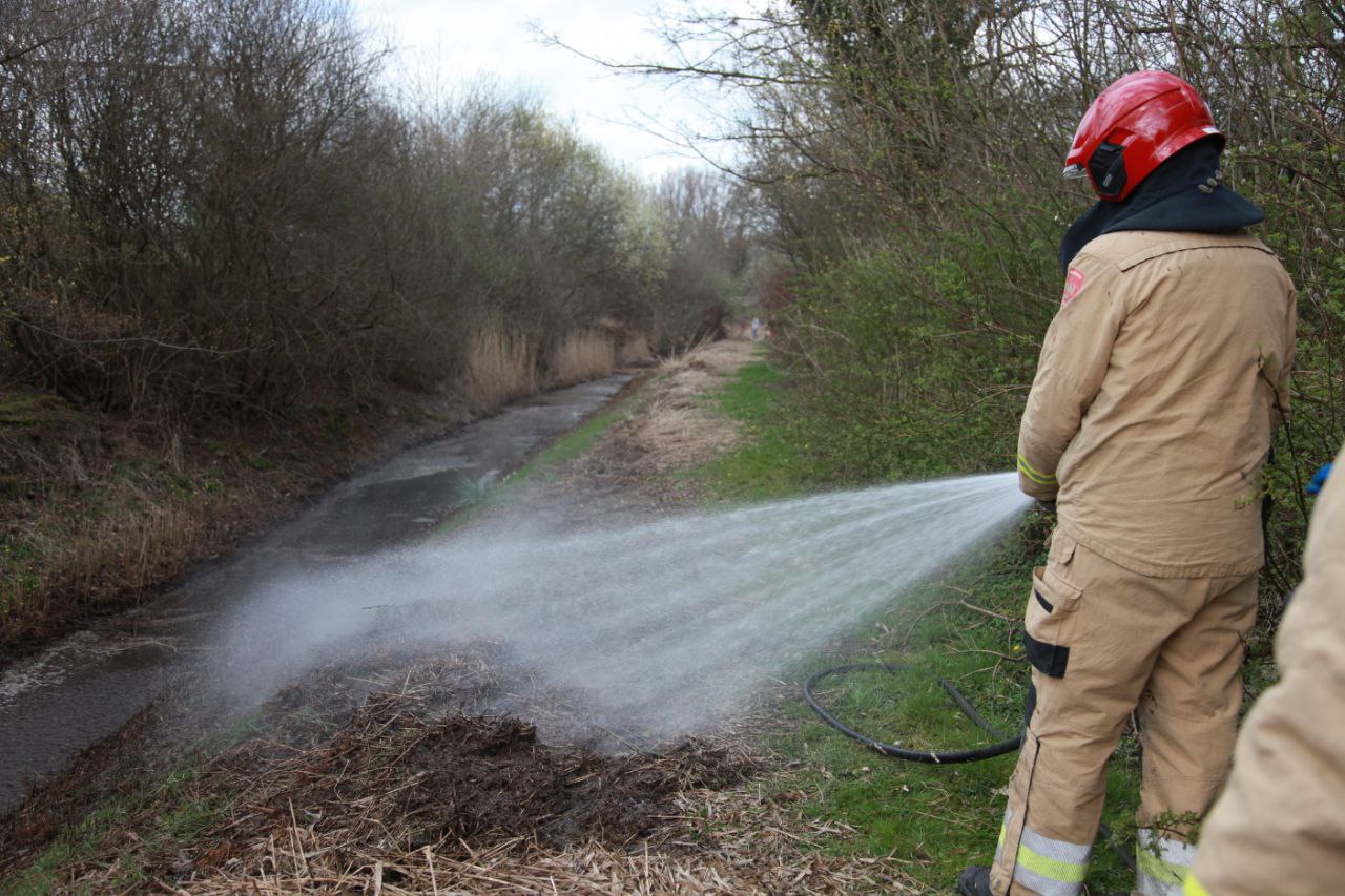 Brandweer blust rietbrand in Haren