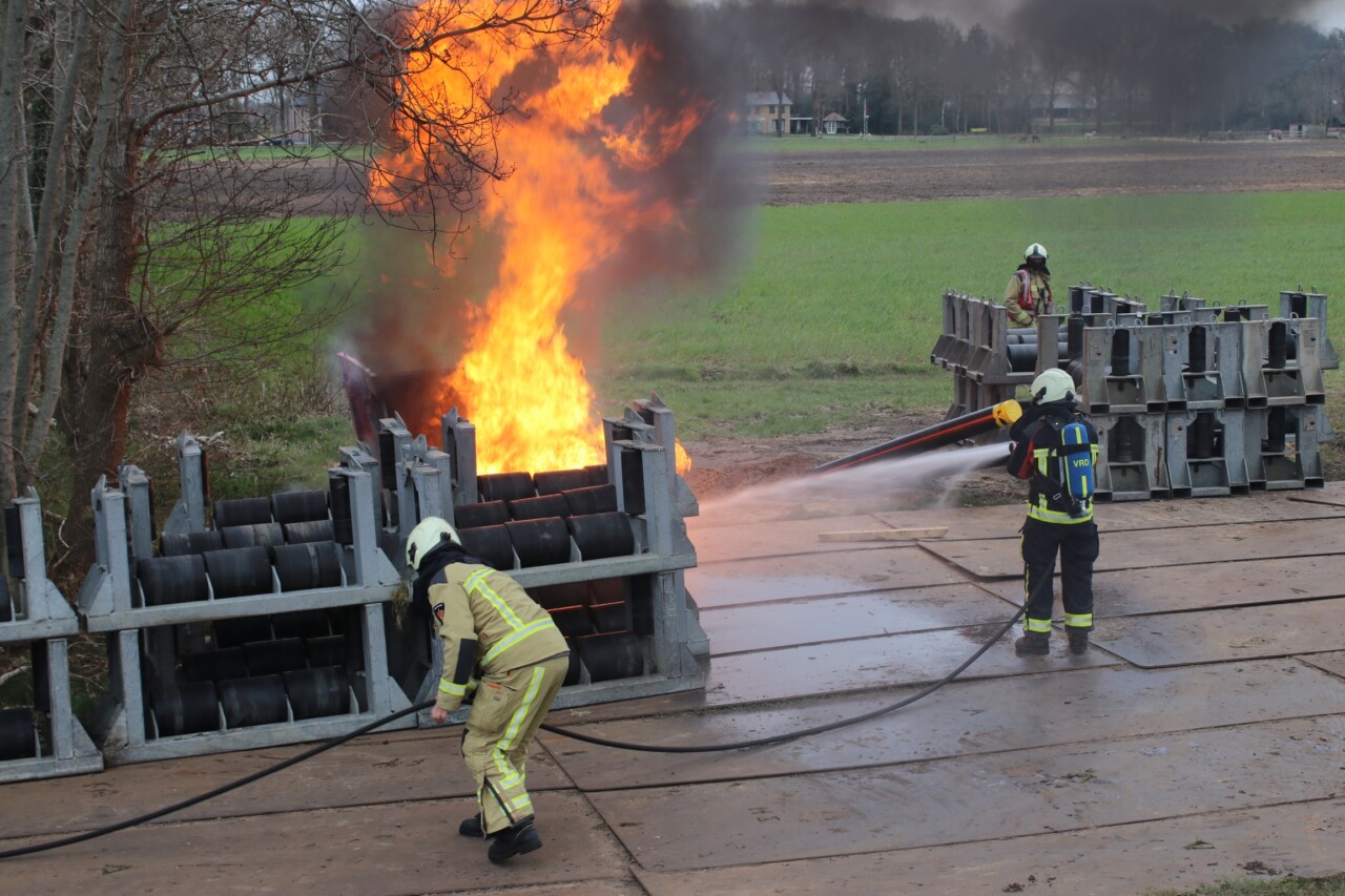 Brandweer blust brand in bouwcontainer