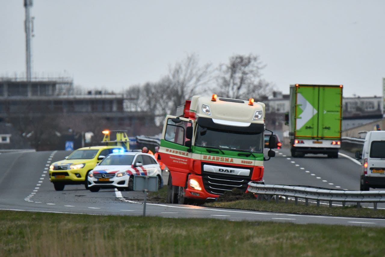 Vrachtwagen ramt vangrail en komt vast te staan in berm