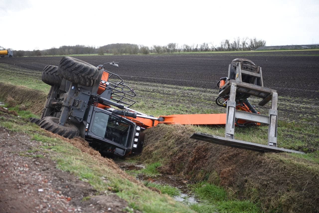 Kraanwagen belandt op zijkant in greppel Nieuwe Pekela