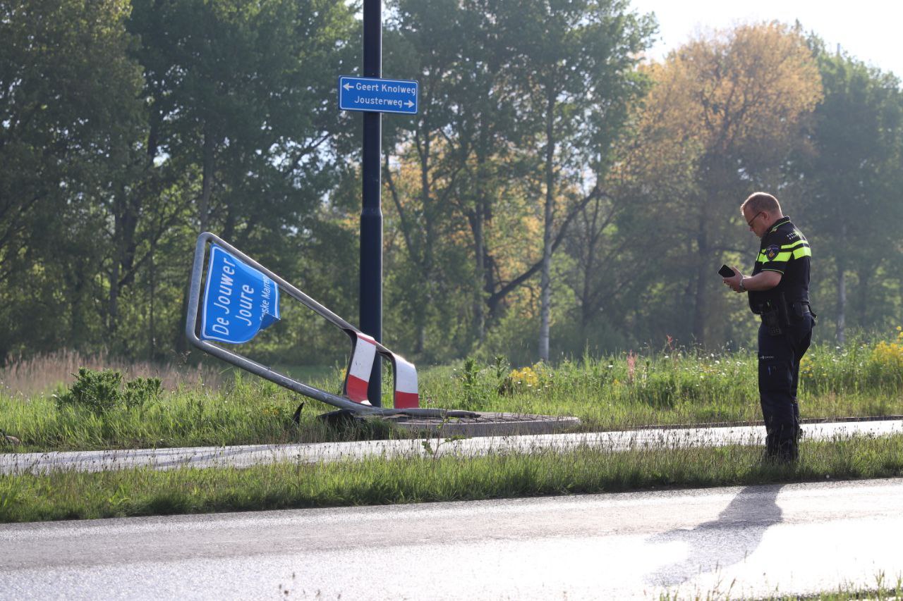 Plaatsnaambord Joure omver gereden; auto rijdt door