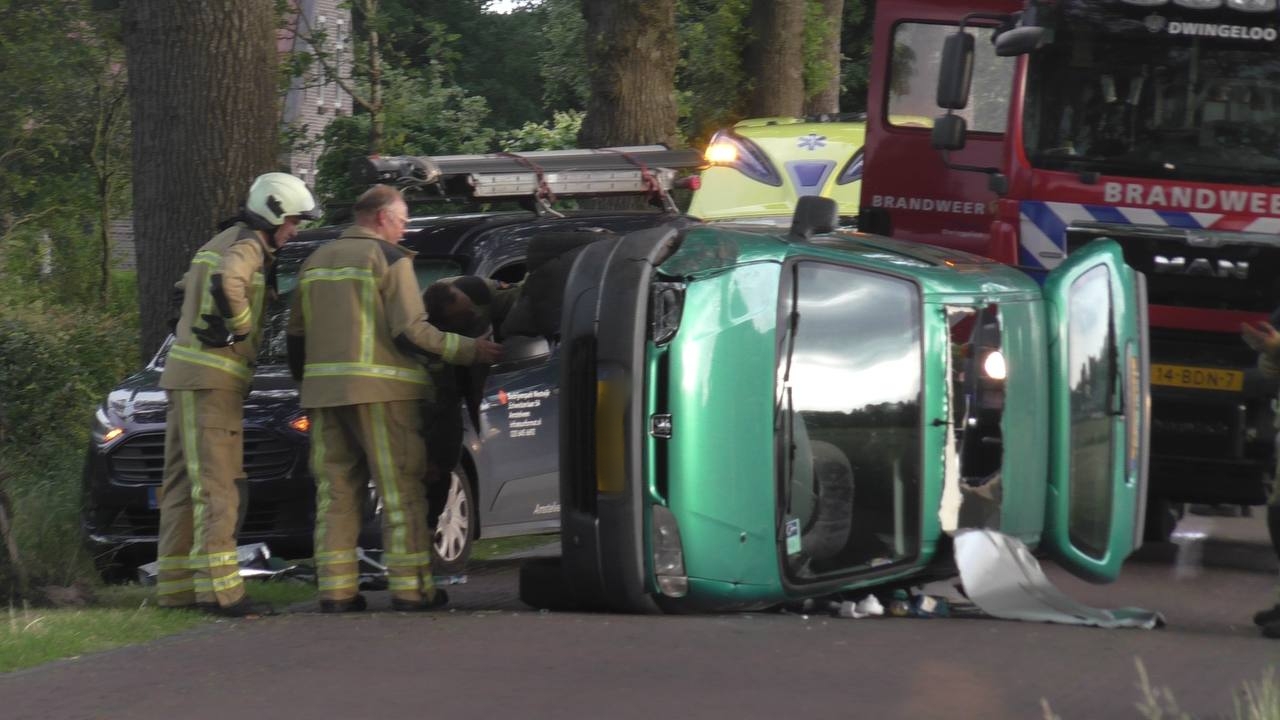 Busje belandt op zijkant; twee gewonden