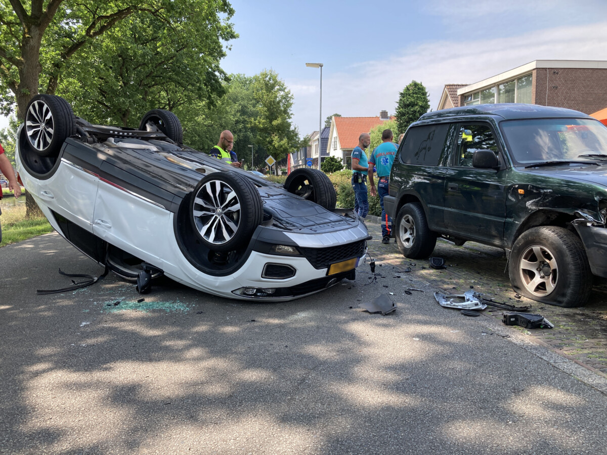 Auto botst tegen geparkeerde auto en slaat over de kop in Erica