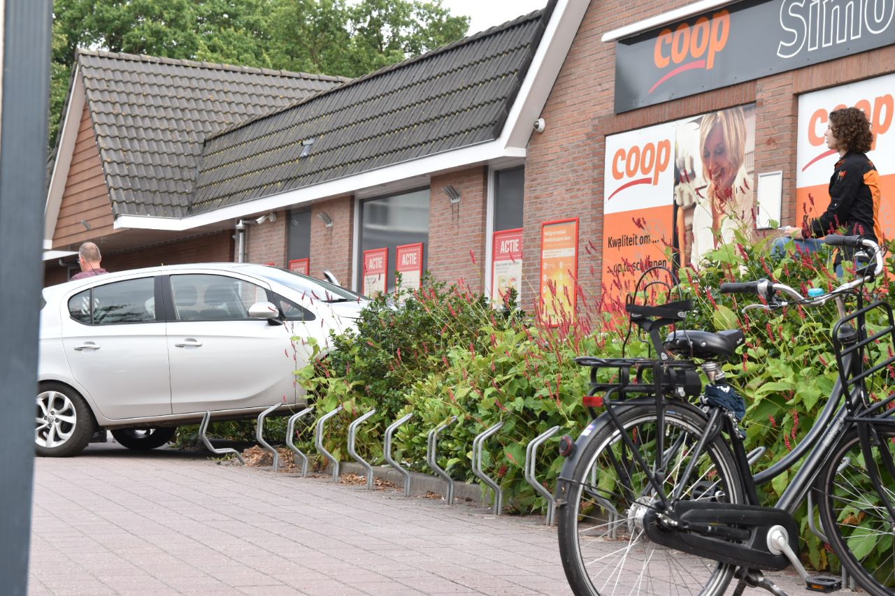 Auto belandt in de struiken voor supermarkt in Vledder