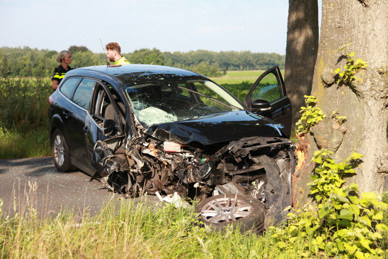 Auto fors beschadigd na botsing tegen boom