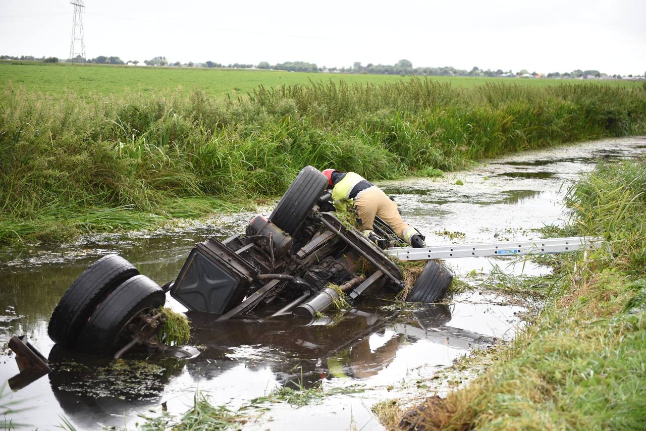 Vrachtwagen belandt op de kop in de sloot; chauffeur gewond