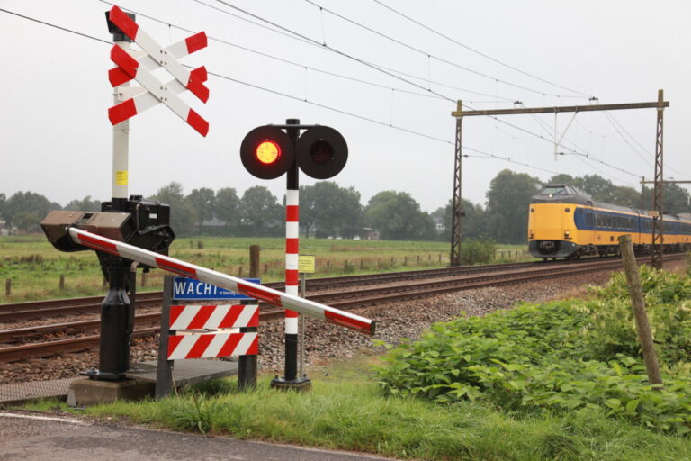 Vrachtwagen ontsnapt aan naderende trein; spoorbomen kapot