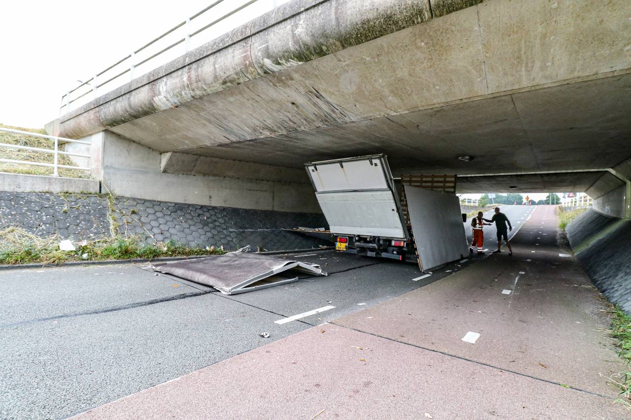 Bestelbus muurvast onder viaduct in Groningen