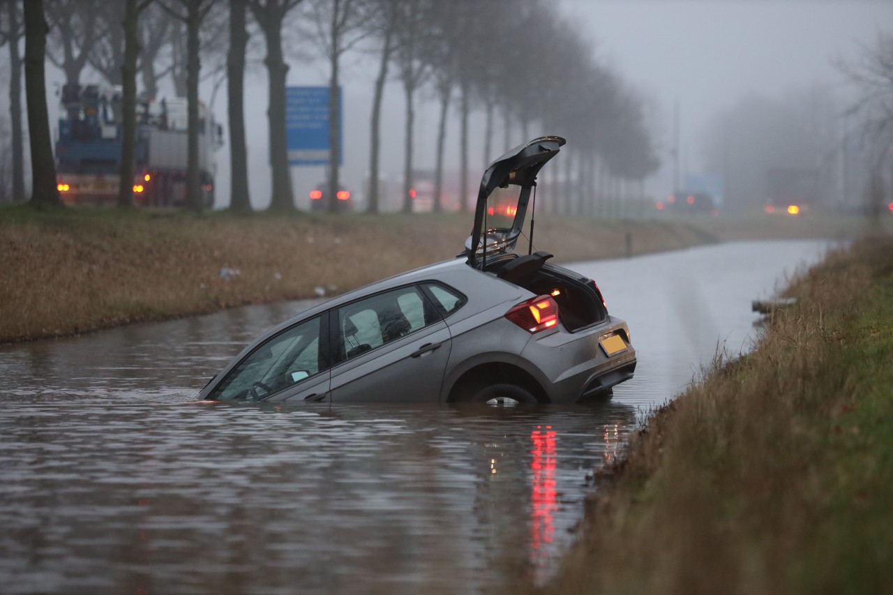 Bestuurder gaat boodschappen doen en vergeet handrem; auto rolt het water in