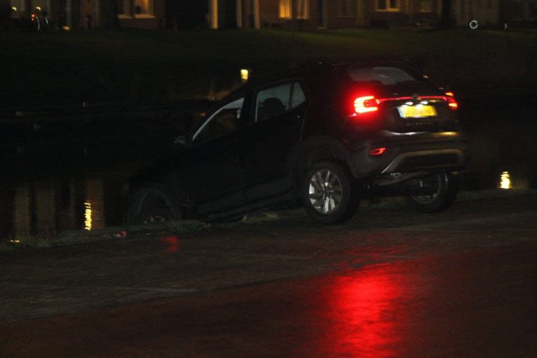 Auto hangt boven water in Dokkum