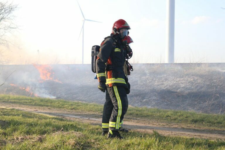 Brandweer blust bermbrand langs treinspoor in Scheemda