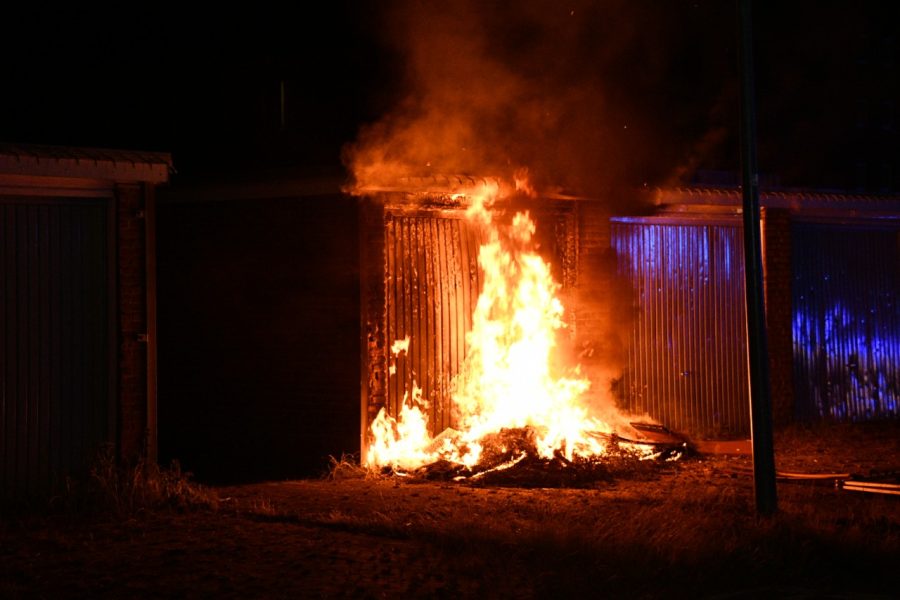 Stapel met hout tegen garage in brand gestoken in Assen