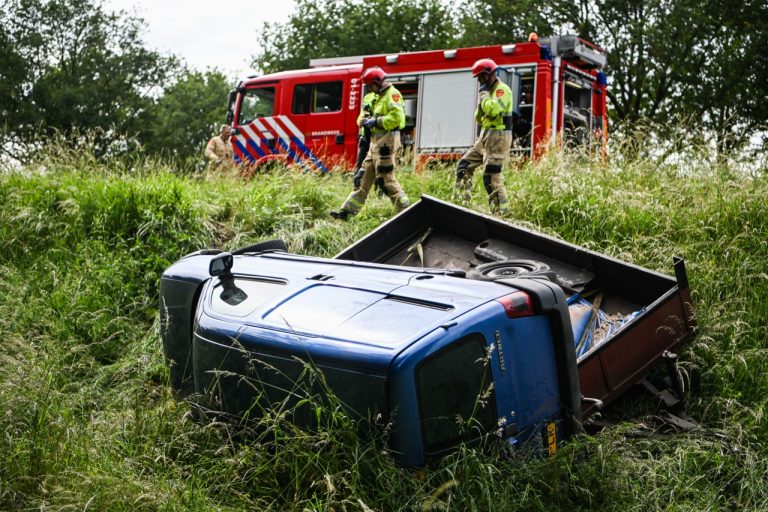 Auto belandt met aanhanger naast de weg bij Slochteren