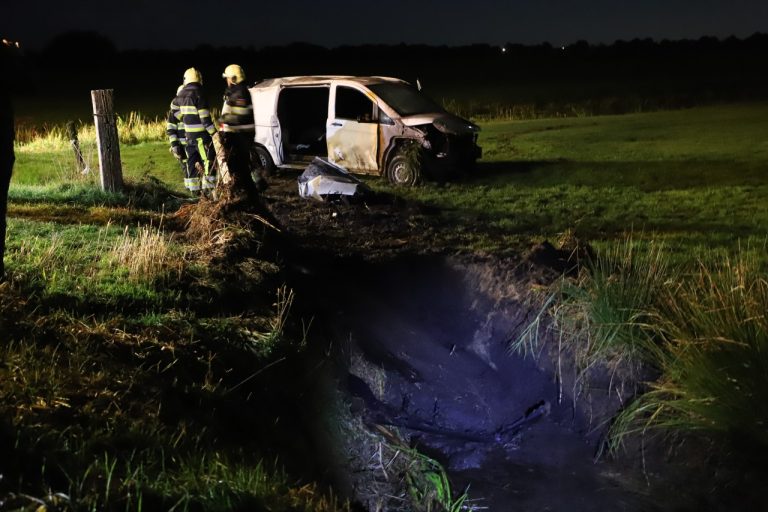 Bestelbus slaat over de kop en eindigt in weiland