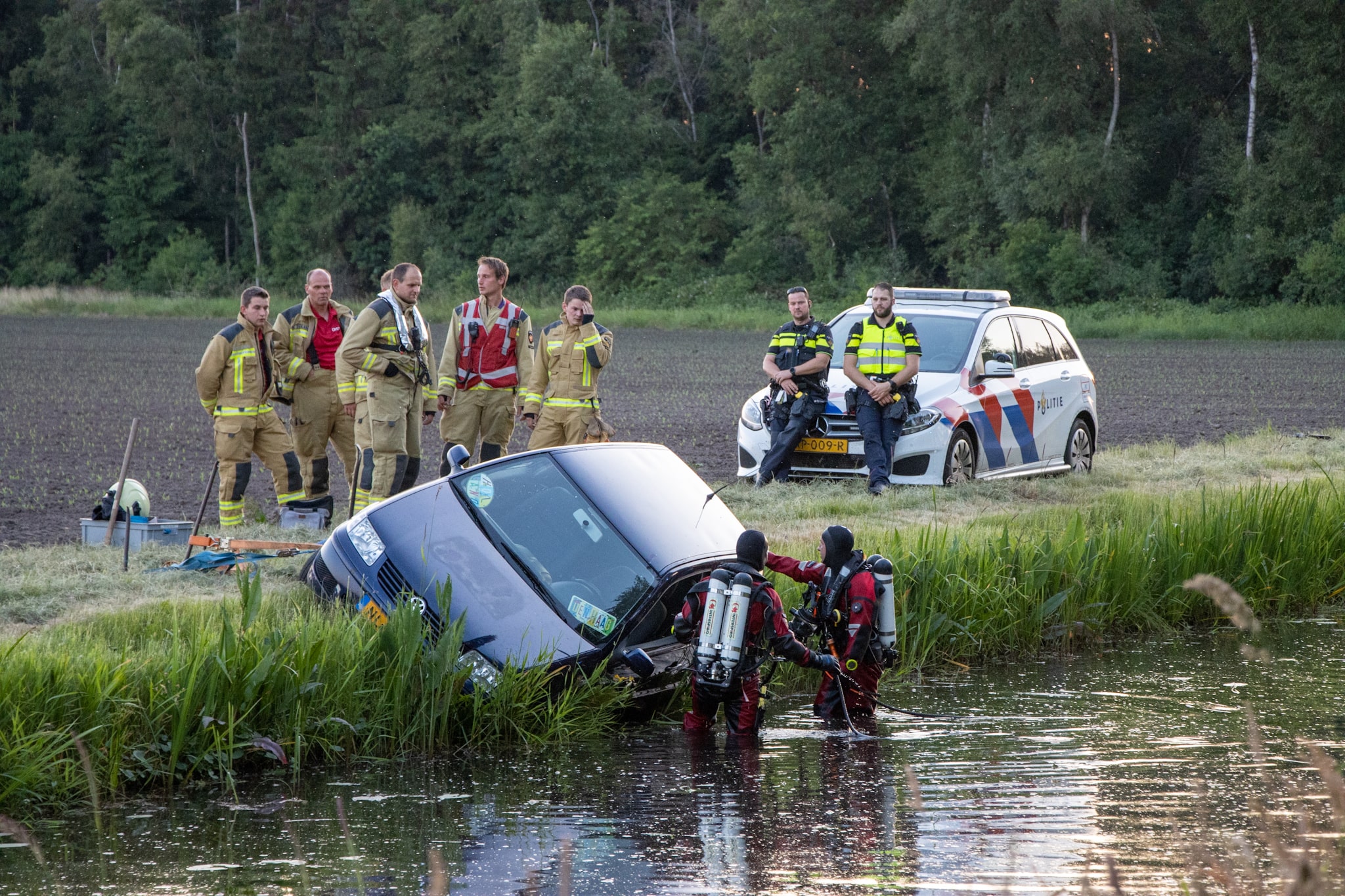 Duikers zoeken in water naar inzittenden auto