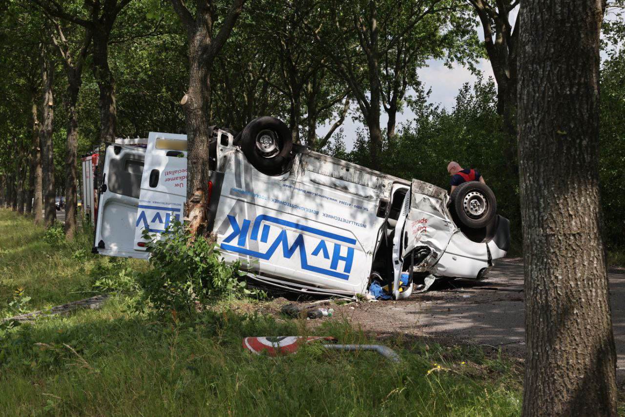 Bestelwagen omgekanteld na botsing, twee personen gewond