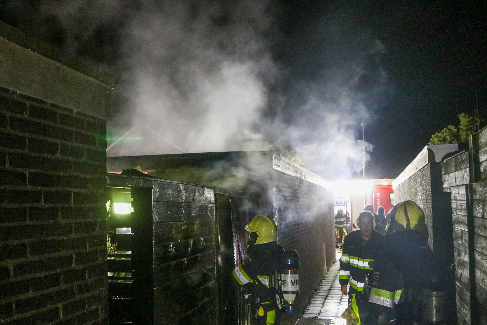 Containers vliegen in brand achter woning