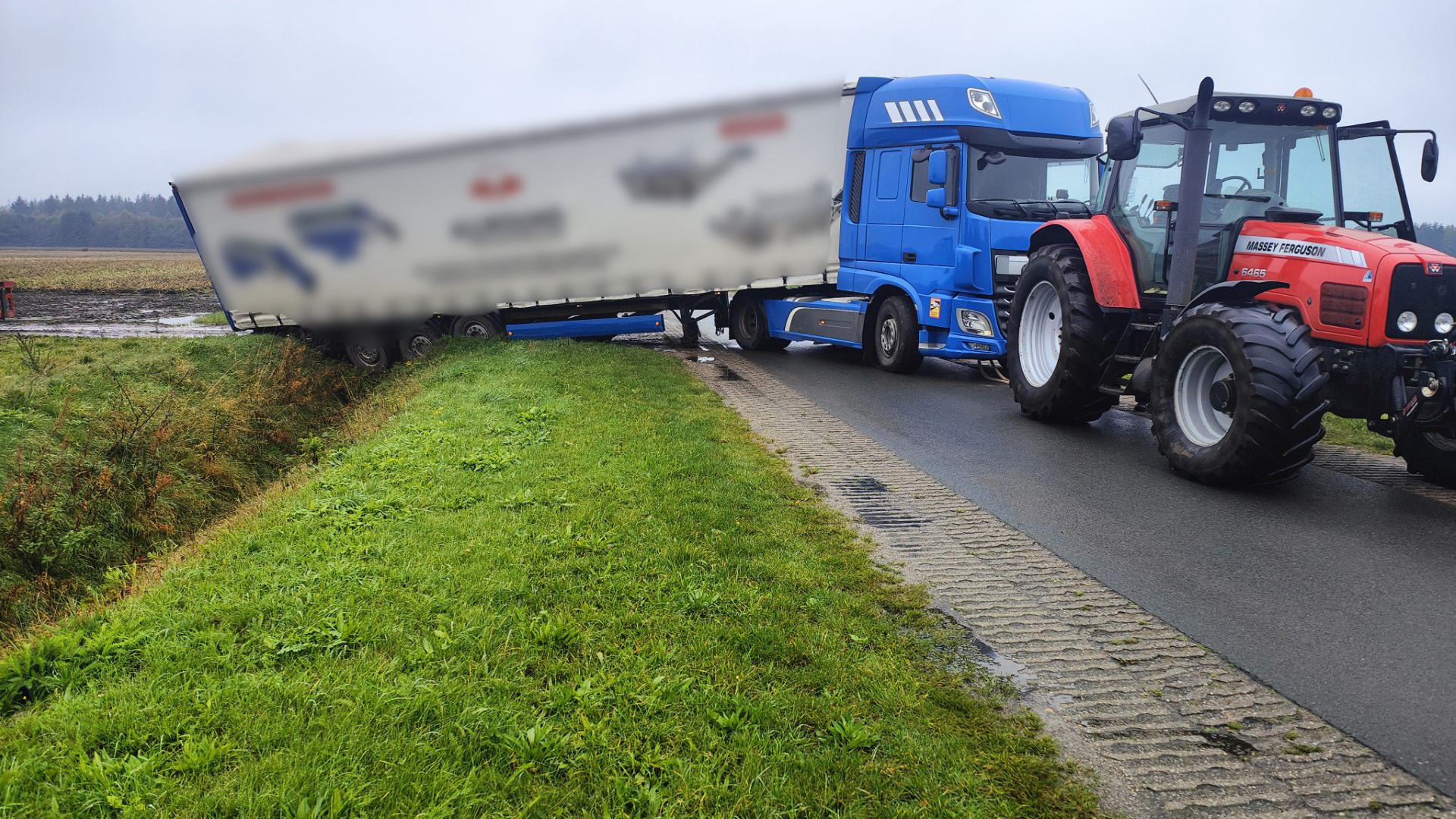 Vrachtwagen met oplegger zakt in drassige sloot in Marwijksoord