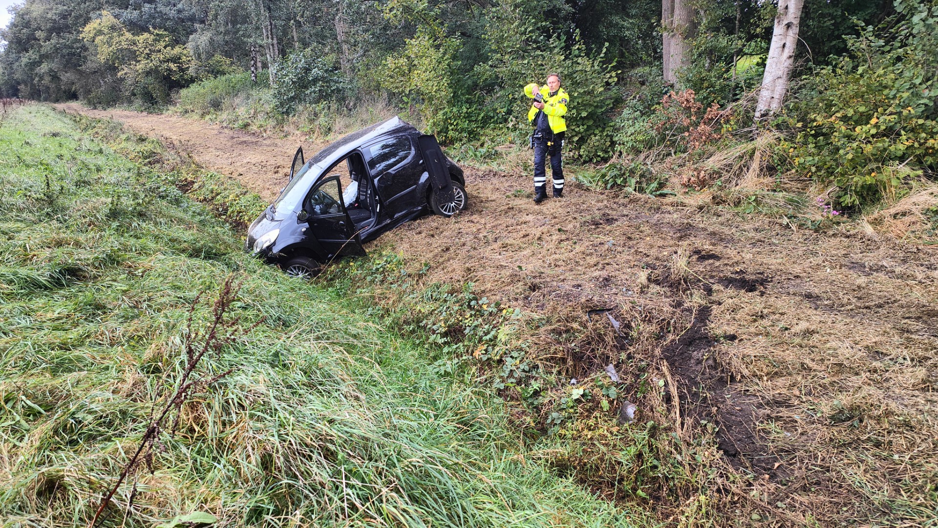 Auto belandt in greppel, vrouw met schrik vrij