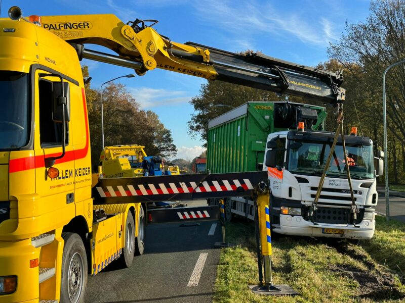 Vrachtwagen zit muurvast in de berm
