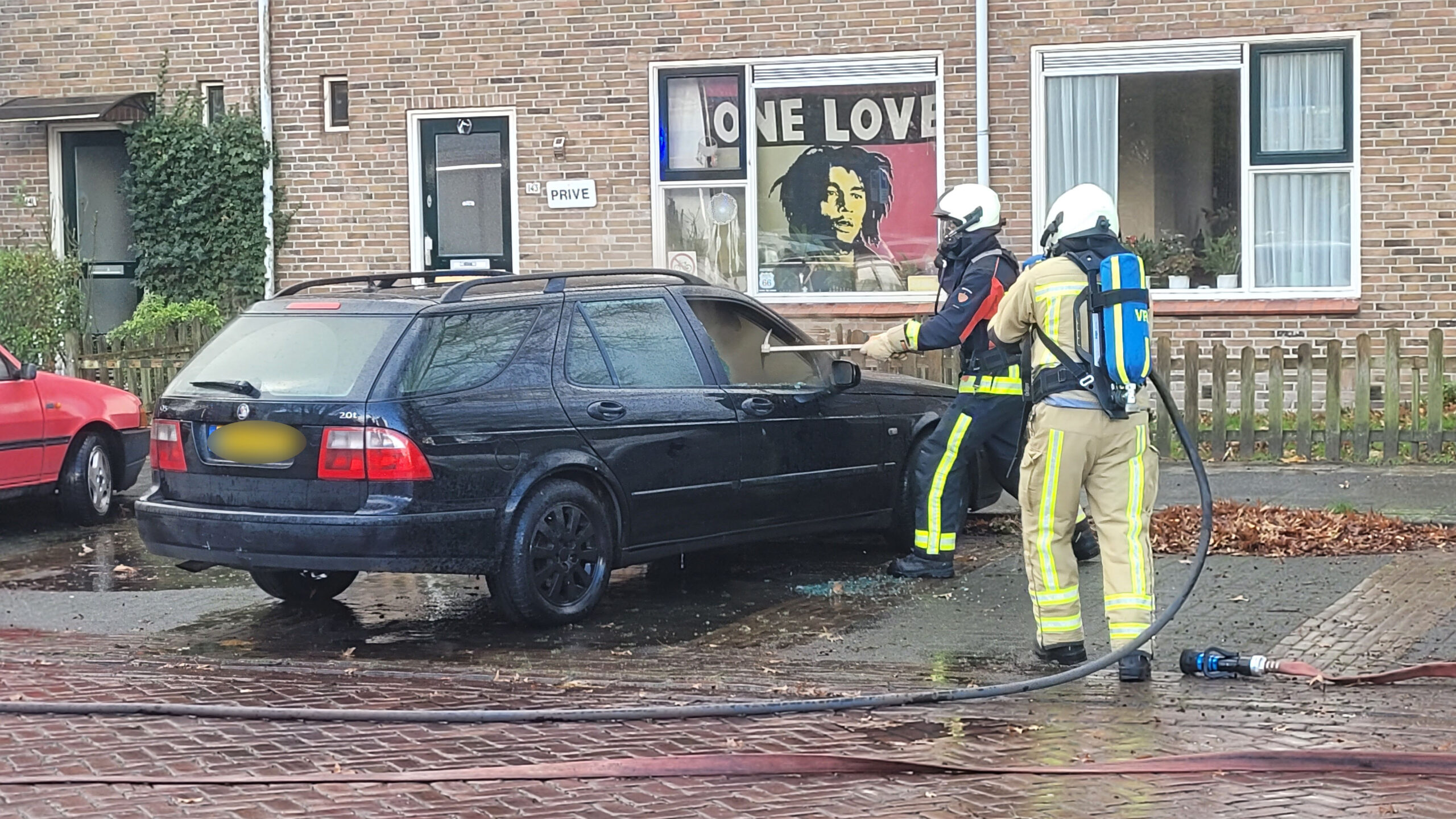 Auto vliegt in brand voor woning, mogelijk technisch mankement