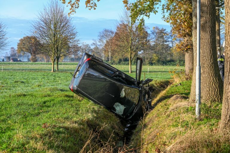 Auto slaat over de kop en belandt in greppel na ongeval met vuilniswagen