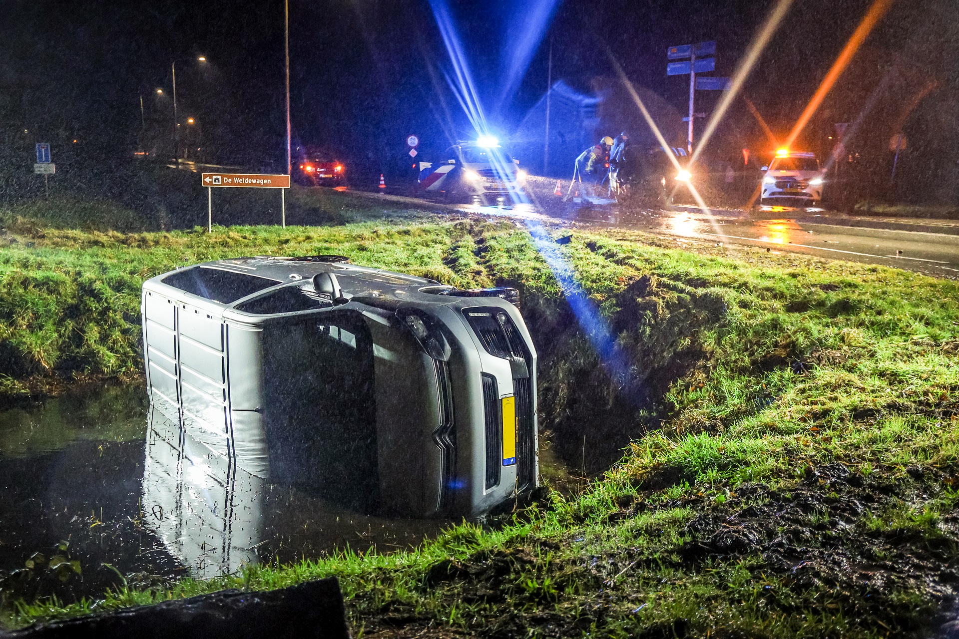 Busje op de zijkant in de sloot na botsing