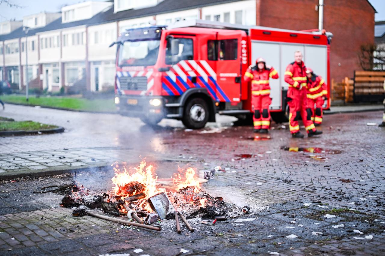 Brandweer blust berg met afval en verkeersborden