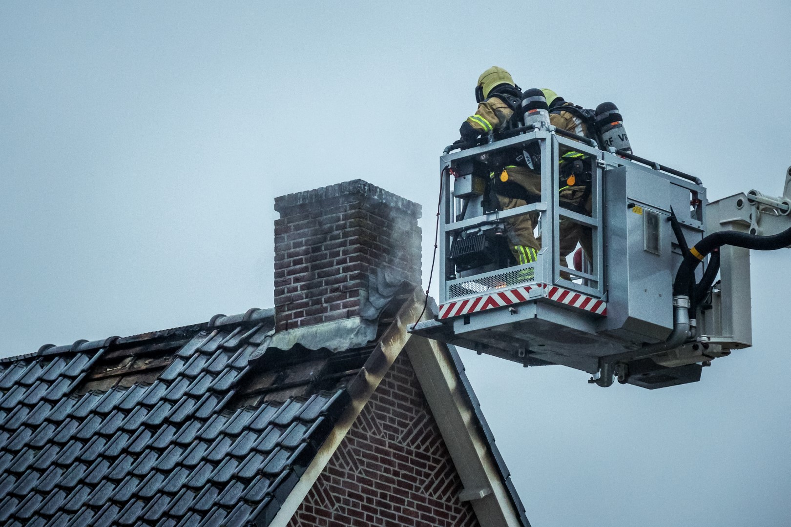 Brandweer verwijdert plafond en deel dak om schoorsteenbrand te blussen