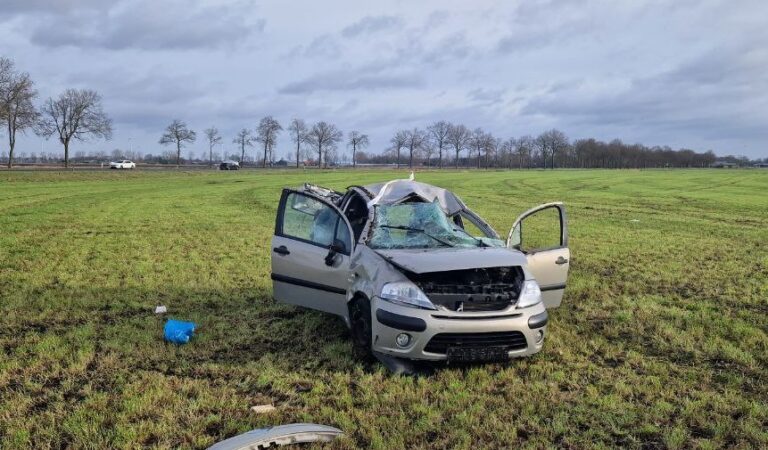 Auto slaat over de kop en komt in weiland terecht