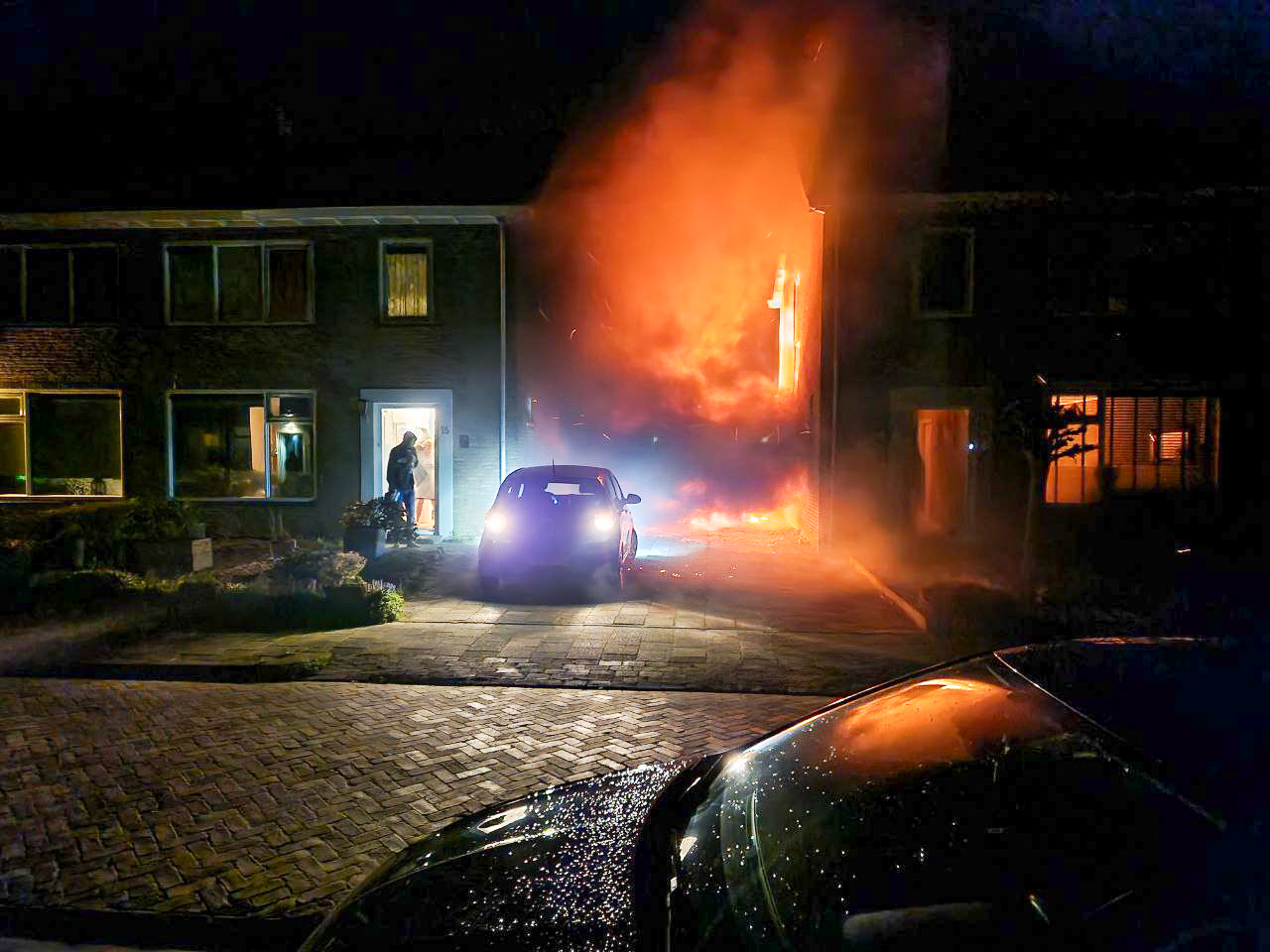 Auto vliegt in brand tussen twee woningen