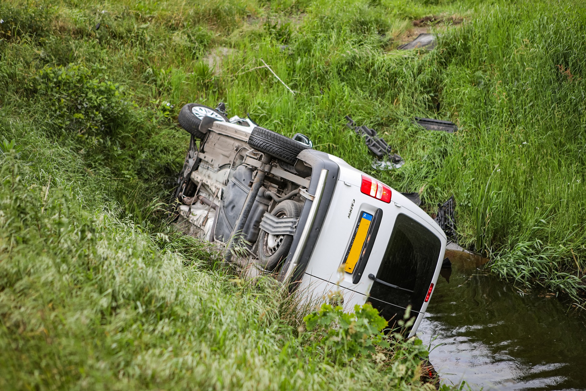 Auto belandt op z’n kant in sloot na botsing op kruising