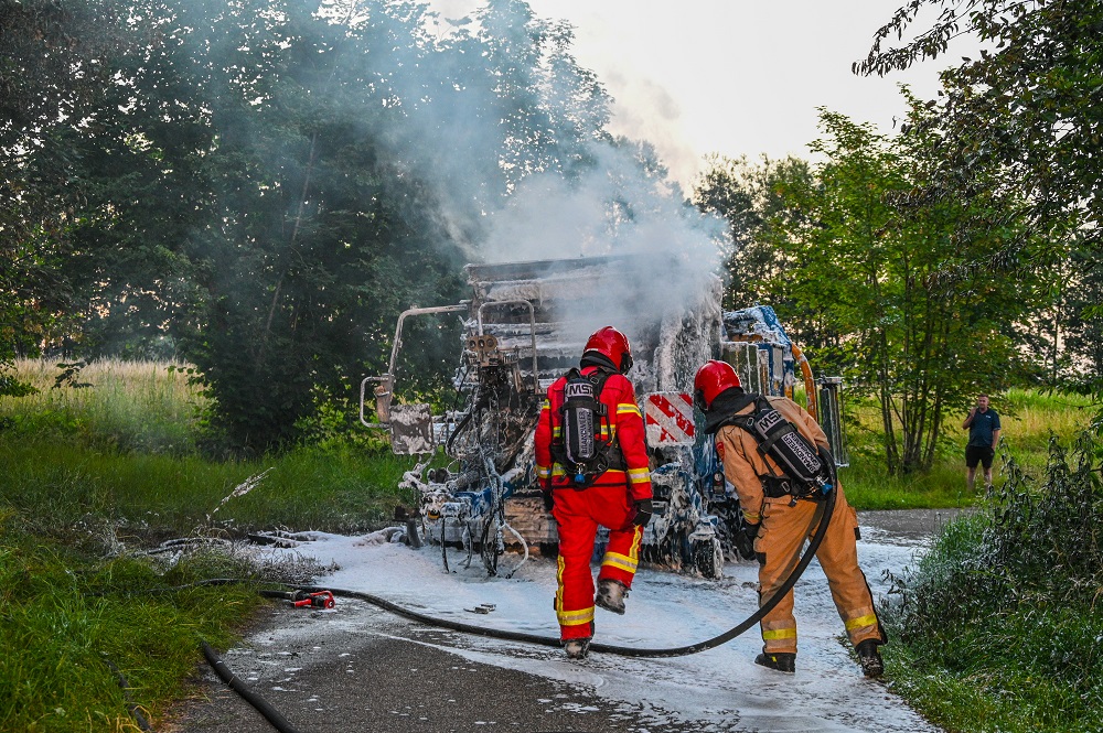 Balenpers achter tractor vliegt in brand, rook in wijde omtrek te zien