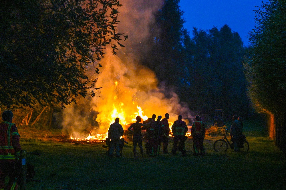 Grote berg snoeiafval in brand, brandweer grijpt niet in