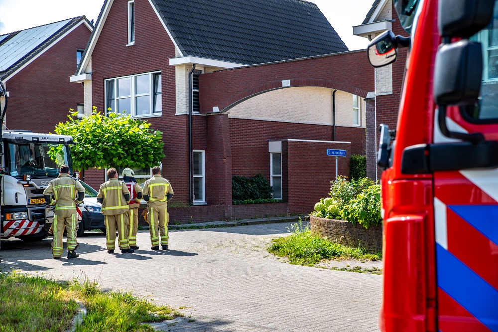 Vrachtwagen ramt stenen boog tussen twee huizen