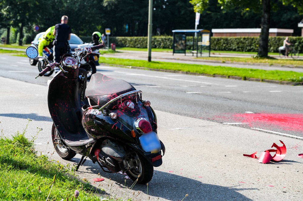 Pot verf klapt open tijdens botsing tussen scooter en auto, scooterrijder gewond naar ziekenhuis