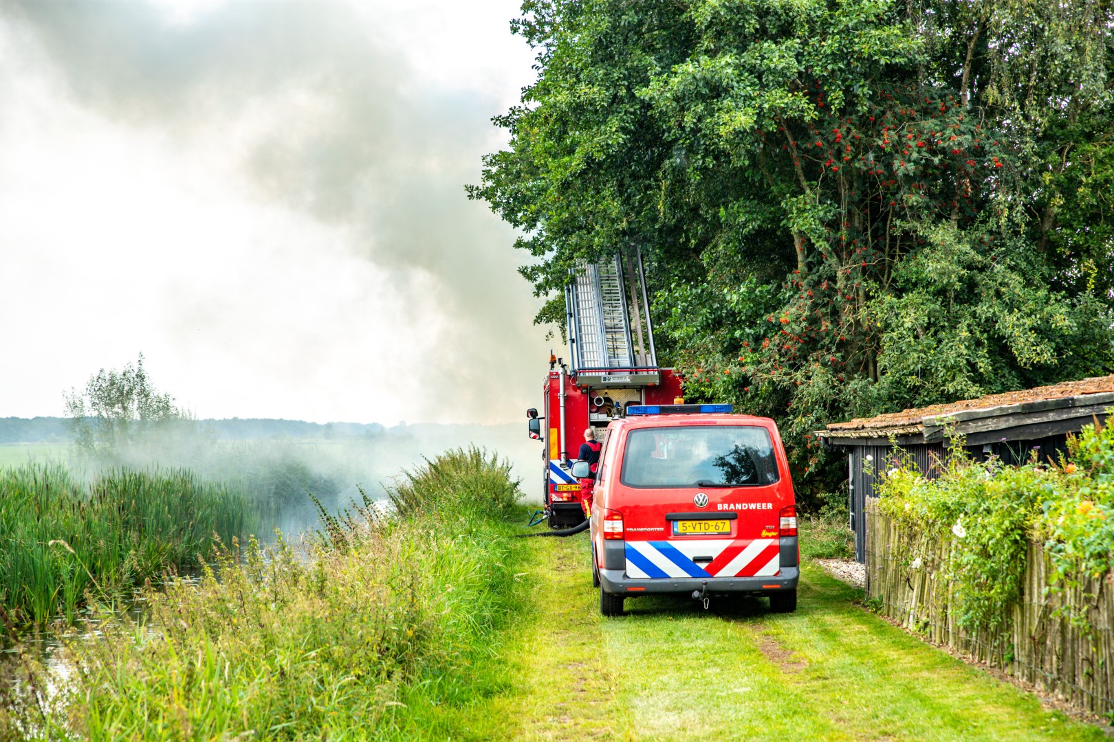 Snoeiafval in brand door barbecue kolen