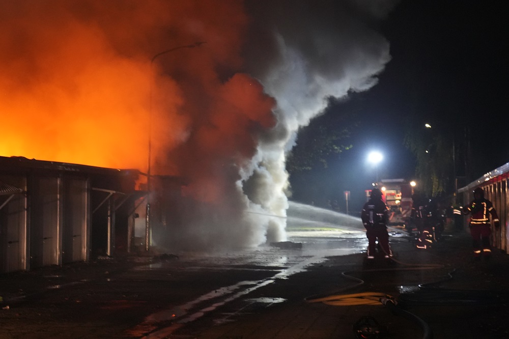 Tien garageboxen in lichterlaaie, brandweer schaalt op naar grote brand