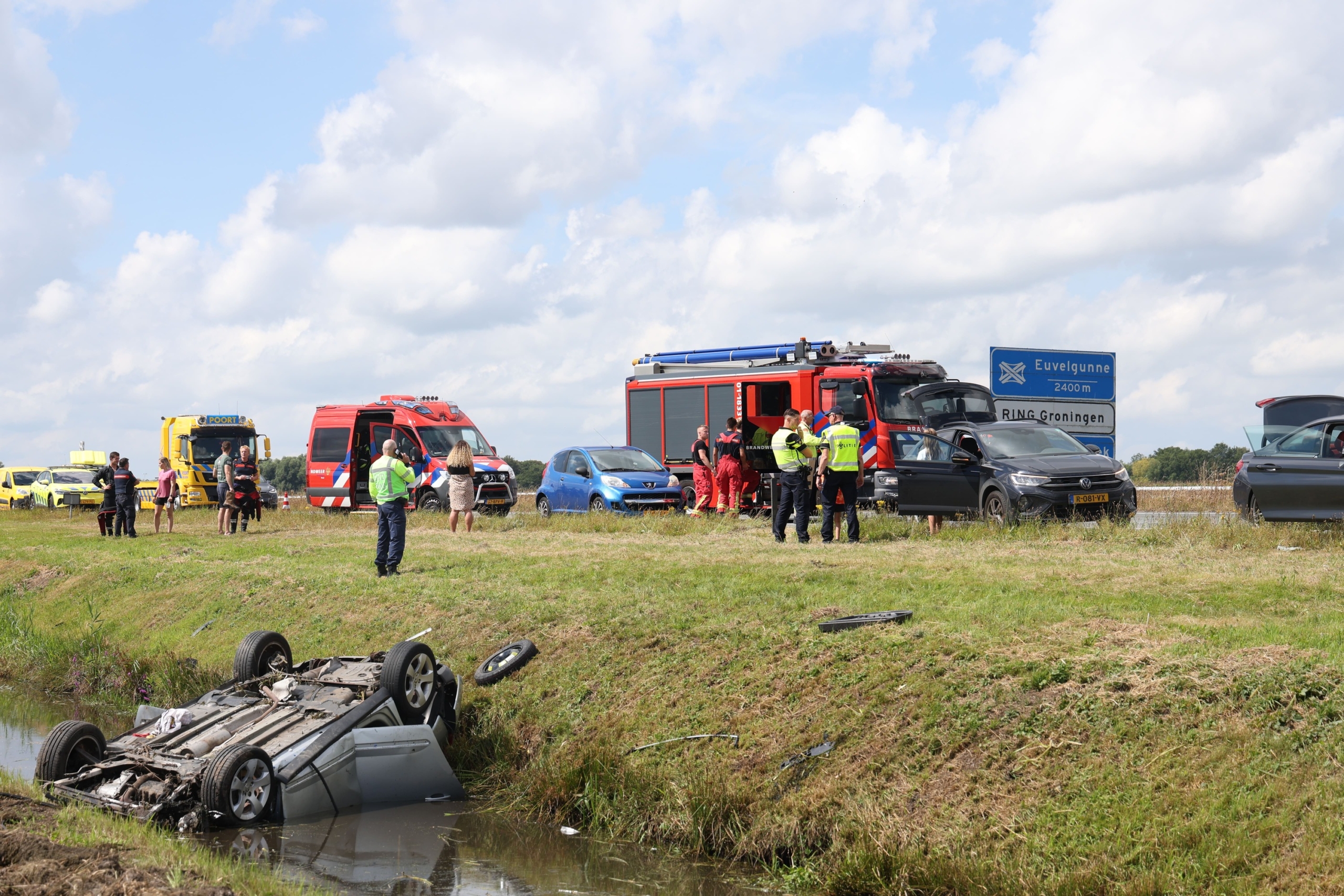 Auto belandt op zijn dak in sloot naast snelweg