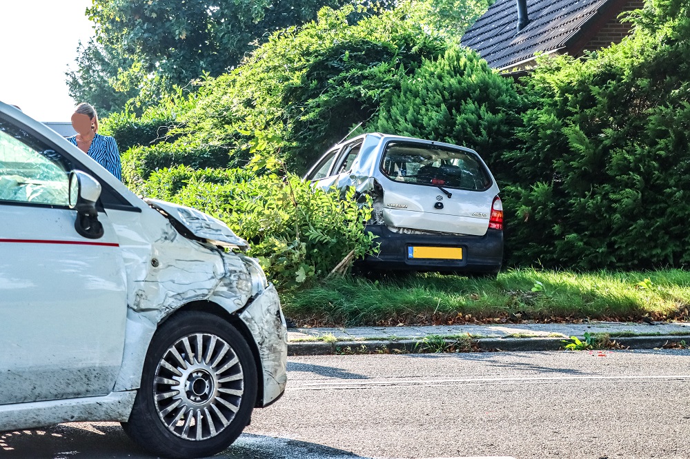 Auto eindigt in bosjes na botsing met geparkeerde auto