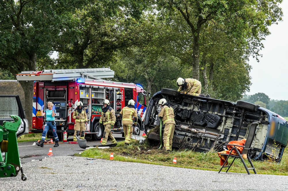 Busje belandt op z’n kant na ongeval, bestuurder bekneld