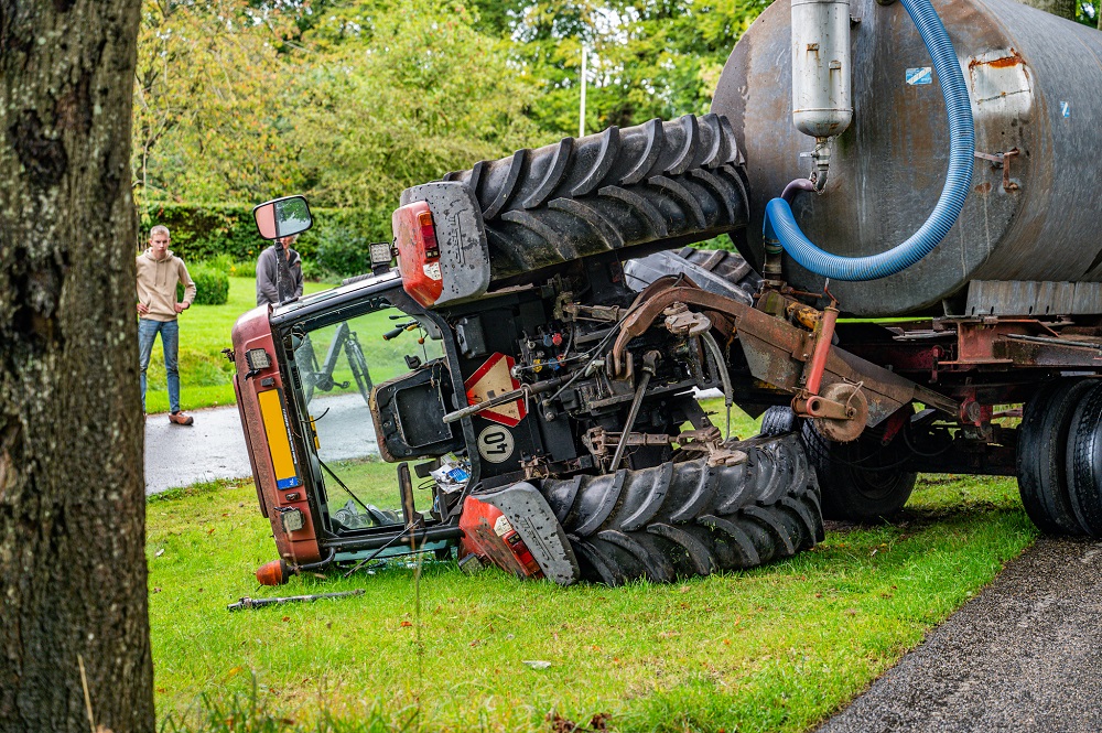 Tractor kantelt na uitwijkmanoeuvre, omstander loopt brandwond op