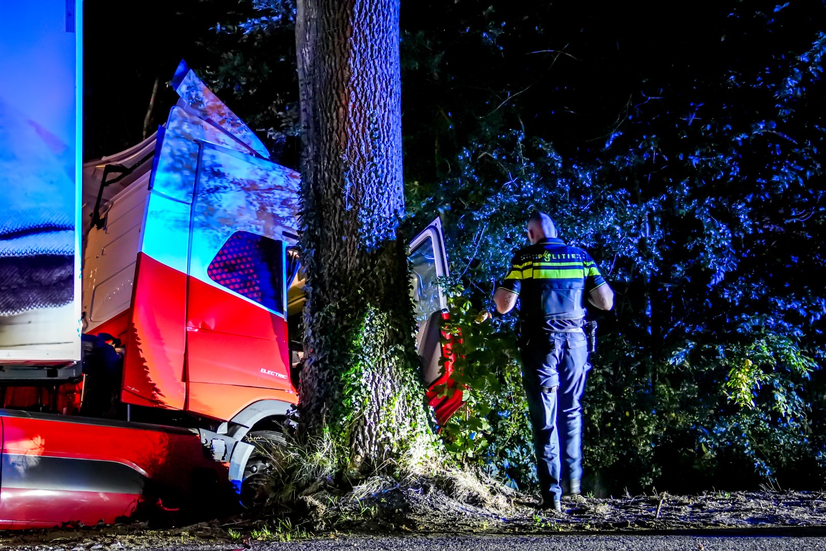 Vrachtwagen botst tegen boom en belandt in sloot: twee personen naar ziekenhuis