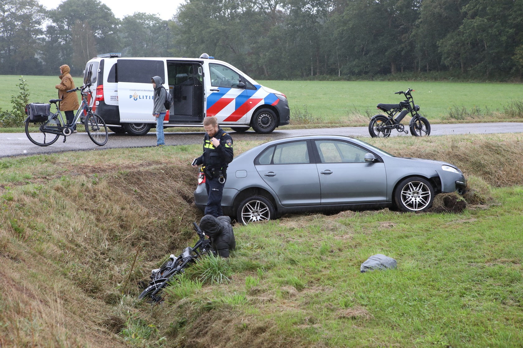 Auto wijkt uit voor fatbiker en belandt in weiland, fietser gewond