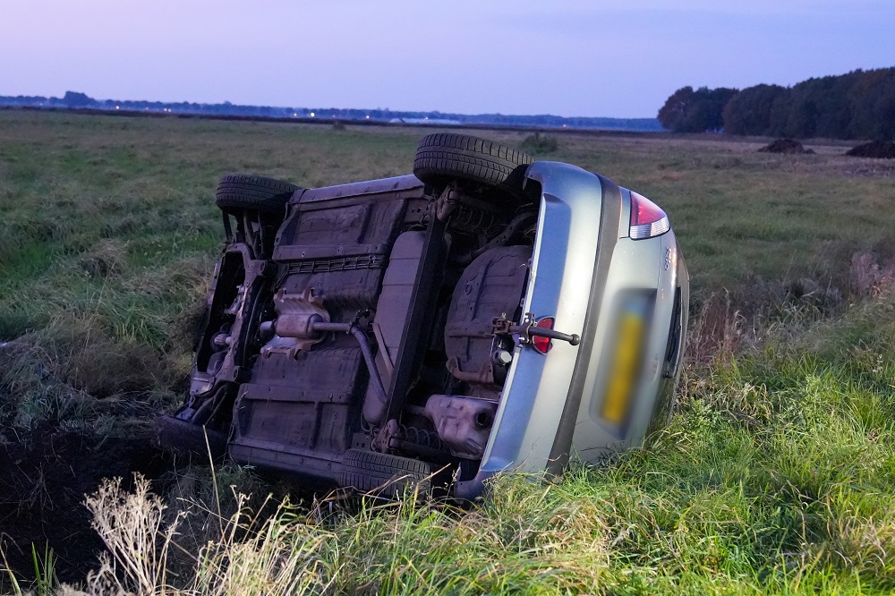 Auto op z’n kant bij ongeval, bestuurder gewond