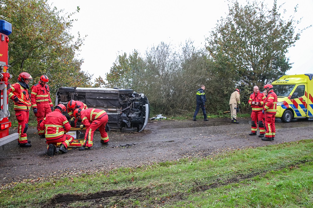 Auto op z’n kant, brandweer bevrijdt bestuurder