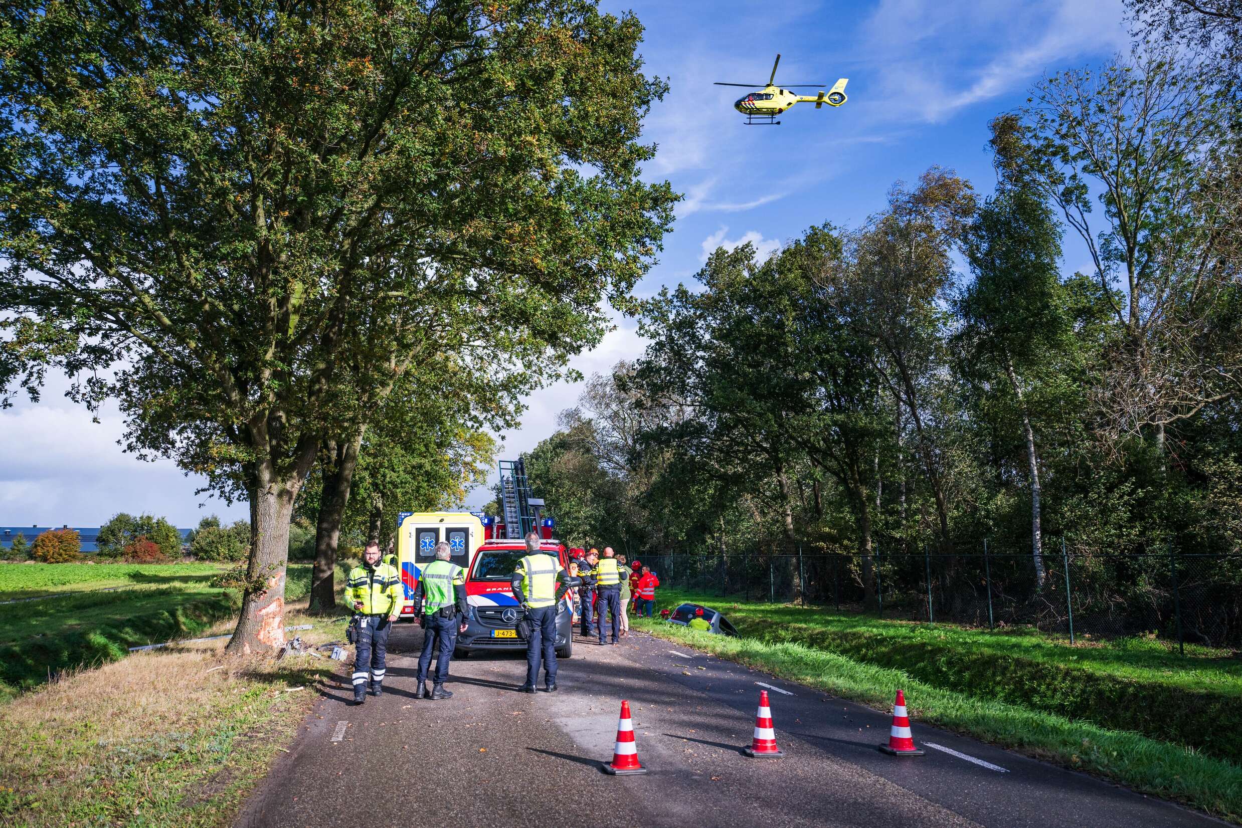 Auto botst frontaal op boom en eindigt in sloot, bestuurder ernstig gewond