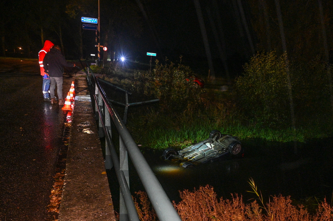 Auto belandt op de kop in sloot na ongeval op brug