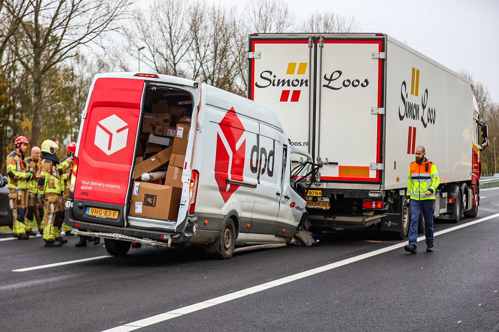 Bestelbus komt onder vrachtwagen terecht, chauffeur gewond